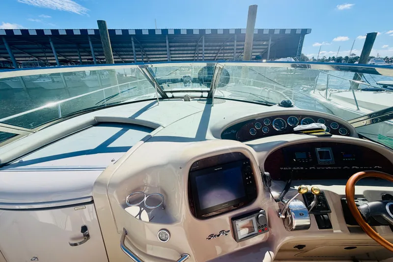 Slide: The Image of Cockpit view of 2000 Sea Ray 410 Sundancer yacht with steering wheel and controls. - 44