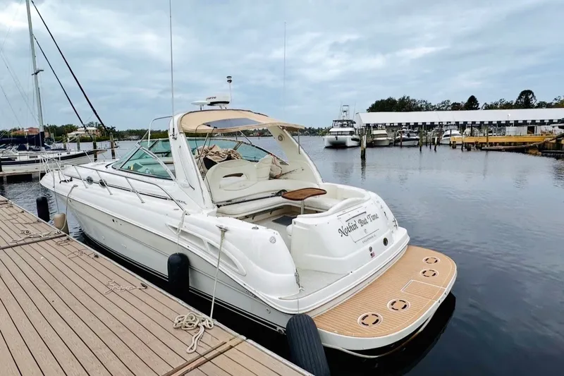 Slide: The Image of 2000 Sea Ray 410 Sundancer yacht docked at a marina, showcasing sleek design and spacious deck. - 71