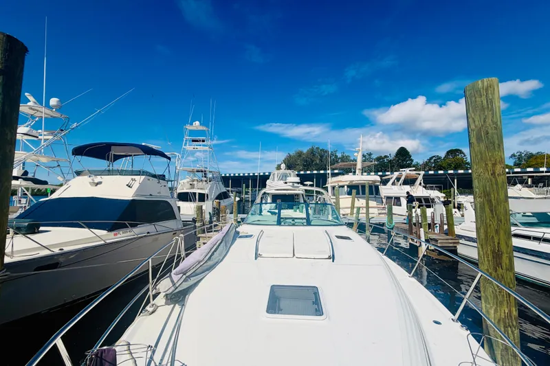 Slide: The Image of 2000 Sea Ray 410 Sundancer yacht docked at marina under clear blue sky. - 27