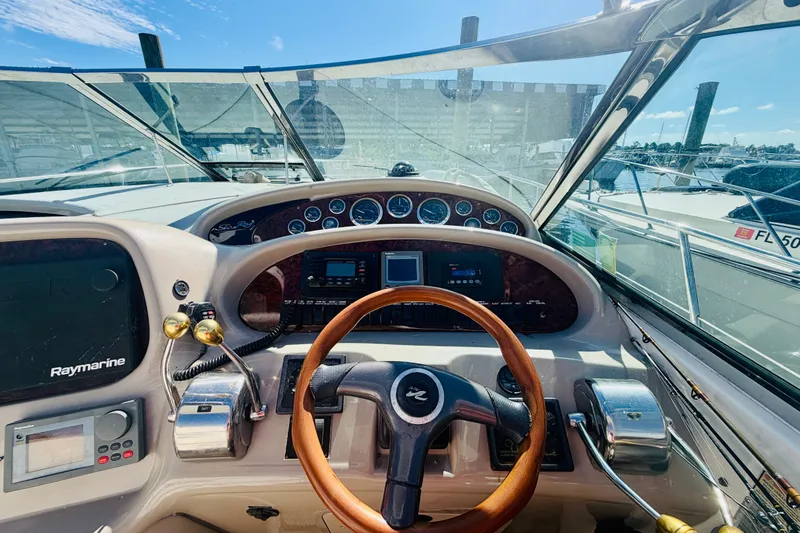 Slide: The Image of Cockpit view of a 2000 Sea Ray 410 Sundancer with steering wheel and navigation instruments. - 38