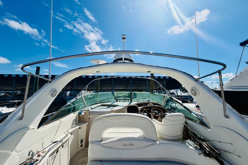 Slide: The Image of 2000 Sea Ray 410 Sundancer yacht interior with helm, under clear blue sky. - 13