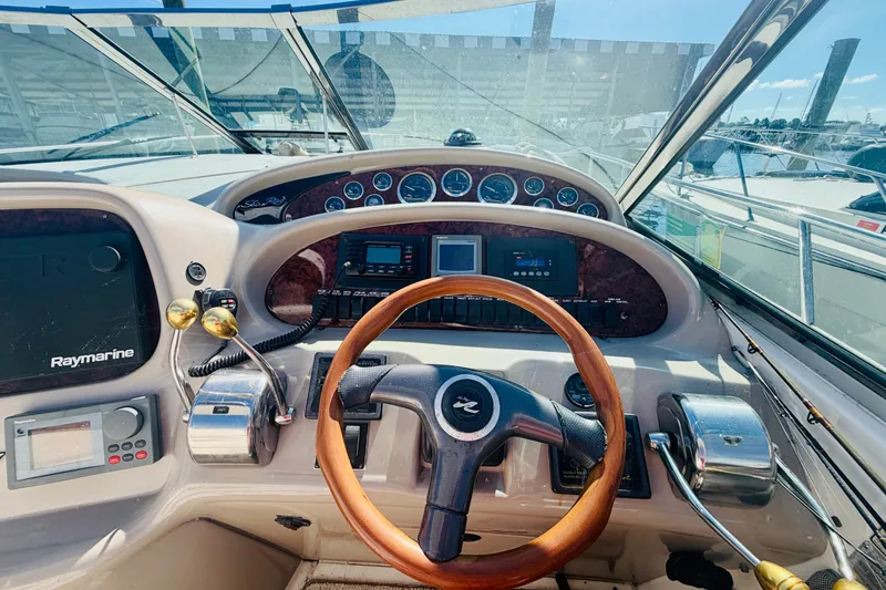 Slide: The Image of Cockpit view of 2000 Sea Ray 410 Sundancer with steering wheel and control panel. - 37