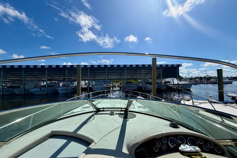 Slide: The Image of Cockpit view from a 2000 Sea Ray 410 Sundancer docked at a marina under blue skies. - 17