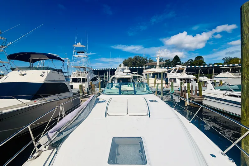 Slide: The Image of 2000 Sea Ray 410 Sundancer yacht docked among other boats under a clear blue sky. - 28