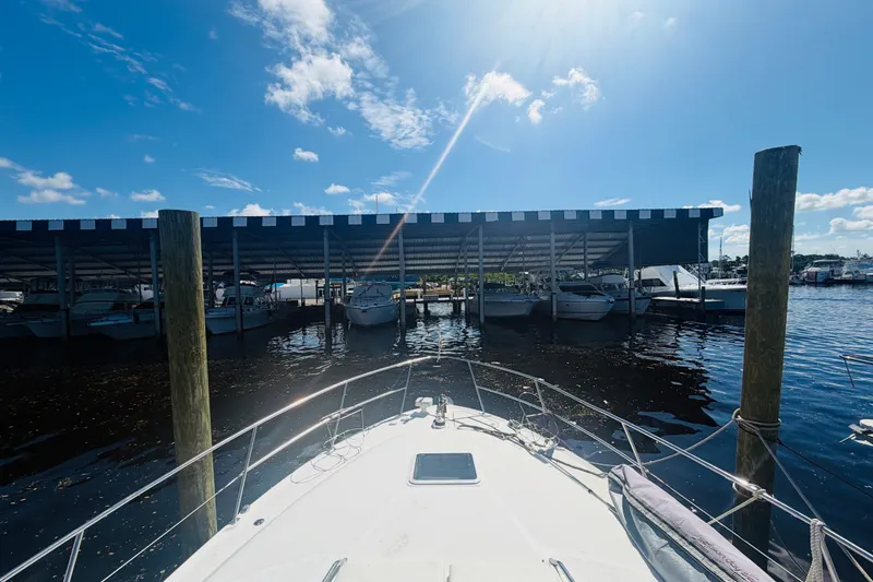 Slide: The Image of Bow view of a 2000 Sea Ray 410 Sundancer docked under a sunny sky. - 22