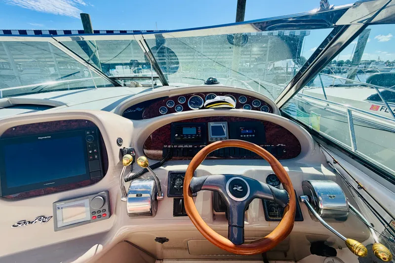 Slide: The Image of Cockpit view of 2000 Sea Ray 410 Sundancer with wooden steering wheel and navigation instruments. - 46