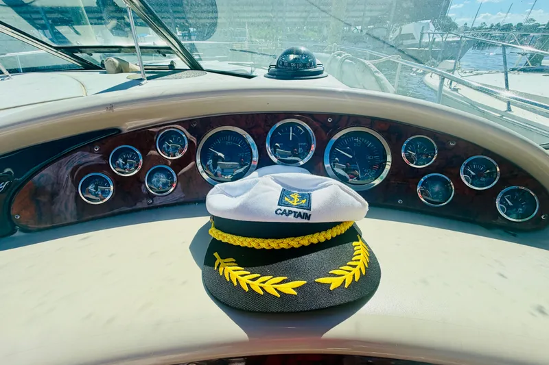 Slide: The Image of Captain's hat on 2000 Sea Ray 410 Sundancer dashboard with gauges and compass. - 47