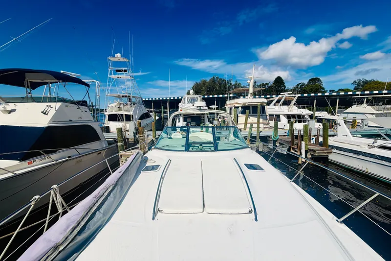 Slide: The Image of 2000 Sea Ray 410 Sundancer docked among other boats under a clear blue sky. - 29
