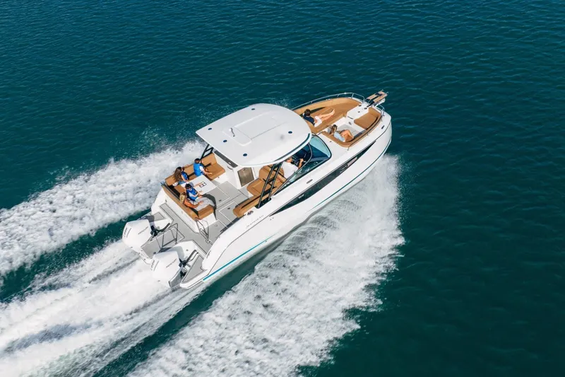 Slide: The Image of 2027 Jeanneau TH33 motorboat cruising on open water with passengers onboard. - 7