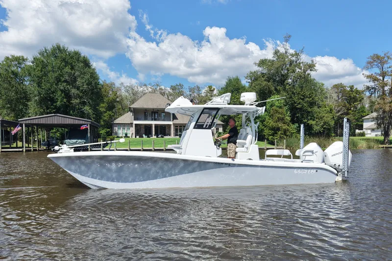 Slide: The Image of 2024 Costa Custom Boats 264HC cruising on a scenic river with lush greenery. - 3