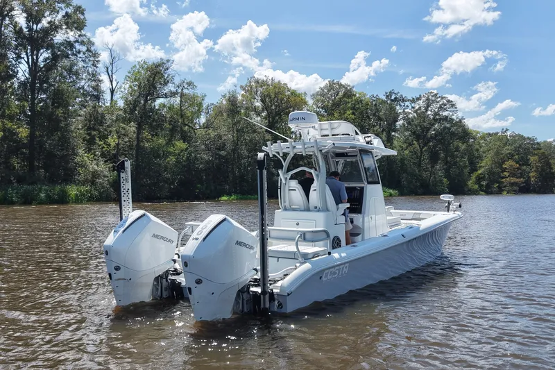 Slide: The Image of 2024 Costa Custom Boats 264HC on a scenic river with twin Mercury engines. - 7
