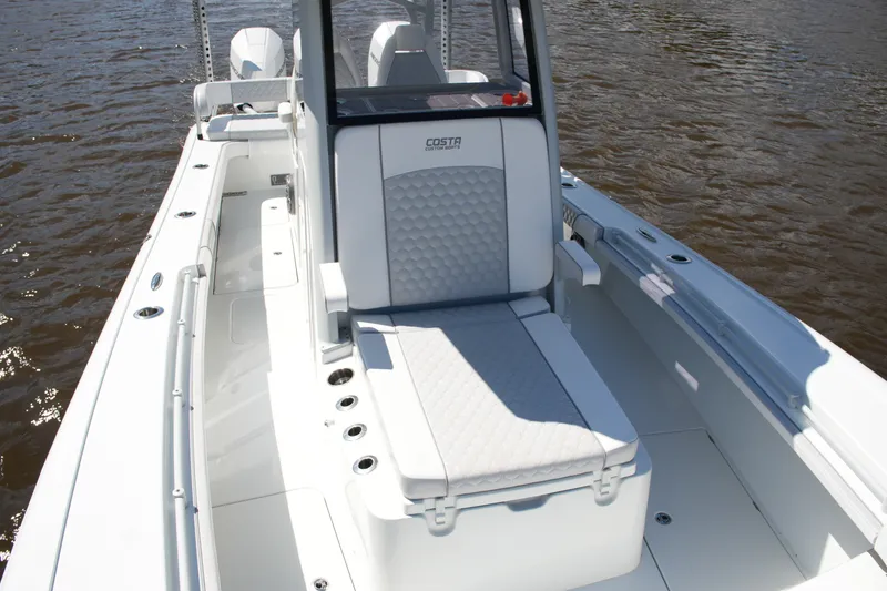 Slide: The Image of 2024 Costa Custom Boats 264HC interior with cushioned seating on the water. - 25