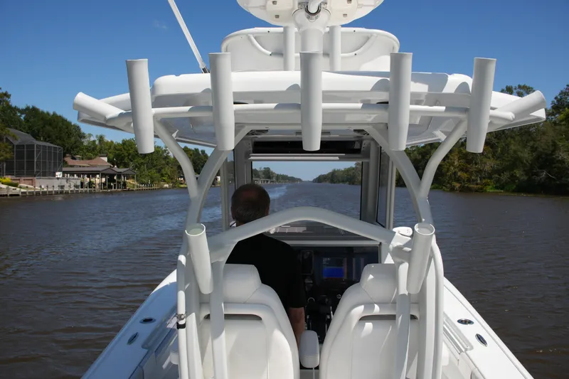 Slide: The Image of 2024 Costa Custom Boats 264HC navigating a scenic river under clear blue skies. - 47