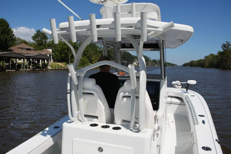 Slide: The Image of 2024 Costa Custom Boats 264HC cruising on a scenic river under a clear blue sky. - 43