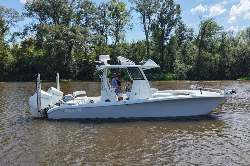 Slide: The Image of 2024 Costa Custom Boats 264HC on a serene river with lush trees in the background. - 10