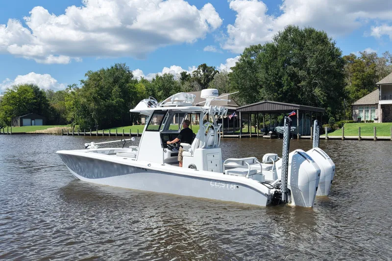 Slide: The Image of 2024 Costa Custom Boats 264HC on a scenic river with lush greenery and blue sky. - 4