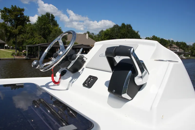 Slide: The Image of 2024 Costa Custom Boats 264HC helm with steering wheel and controls on a sunny day. - 50