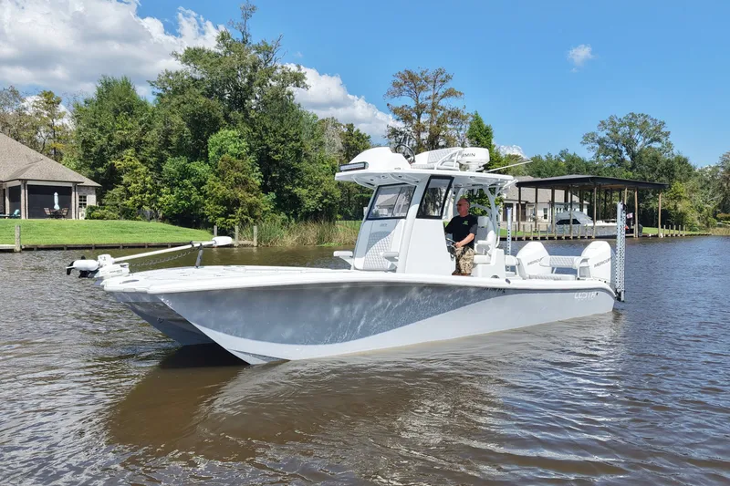 Slide: The Image of 2024 Costa Custom Boats 264HC on a scenic river with lush greenery. - 2