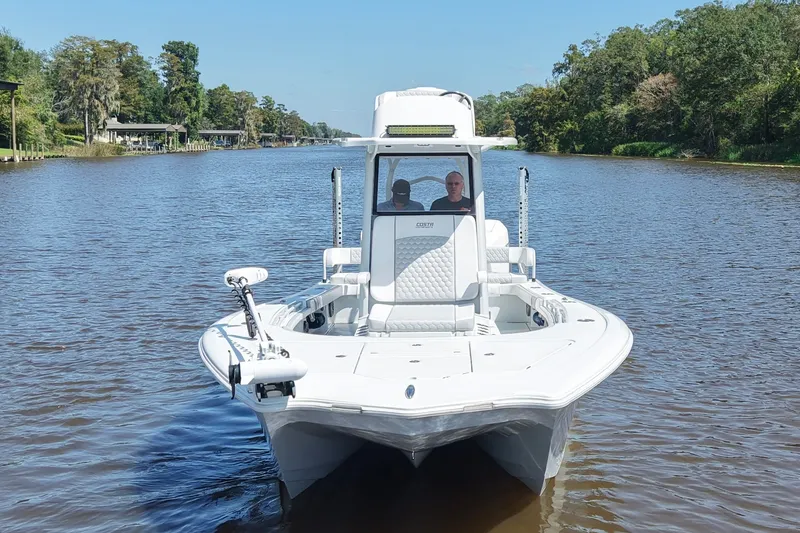Slide: The Image of 2024 Costa Custom Boats 264HC cruising on a scenic river with lush greenery. - 14