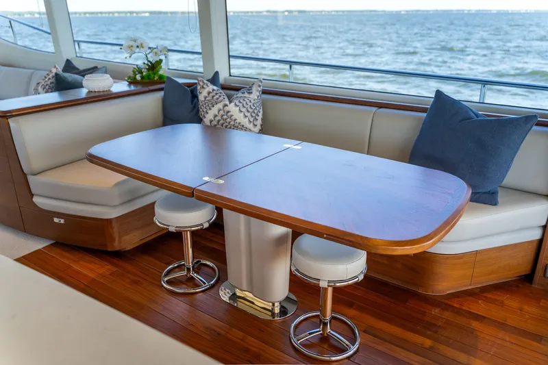 Slide: The Image of Elegant dining area on a yacht with a wooden table, cushioned seating, and ocean view. - 15
