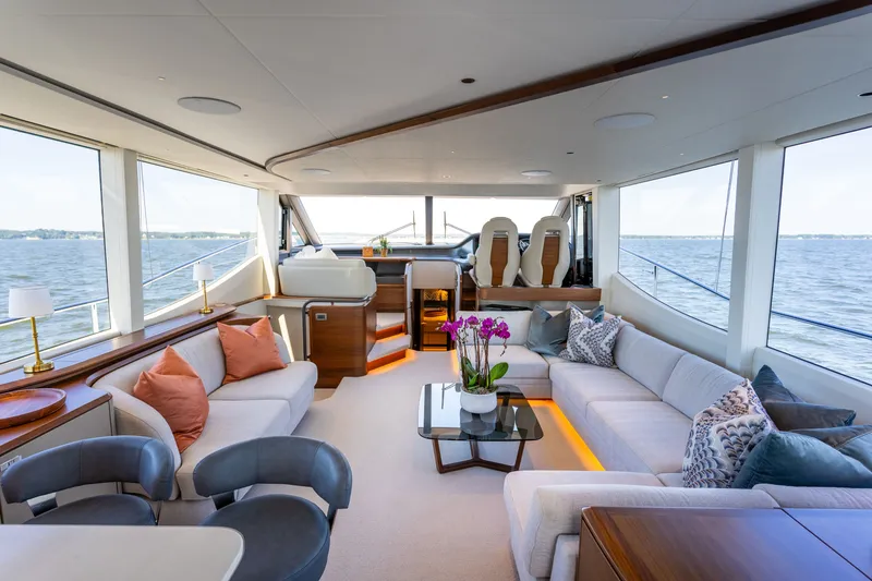 Slide: The Image of Luxurious yacht salon with large windows, white sofas, and a glass table with flowers. - 1