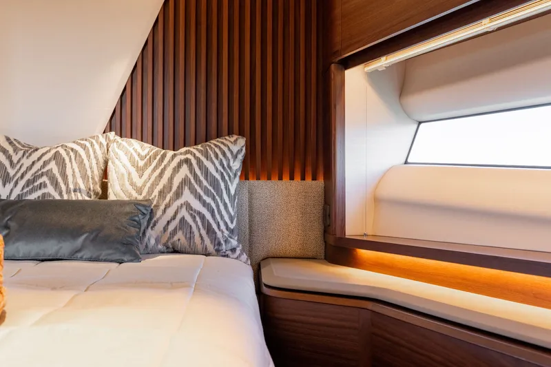 Slide: The Image of Elegant bedroom with wooden walls, modern pillows, and a window with a seating area. - 48