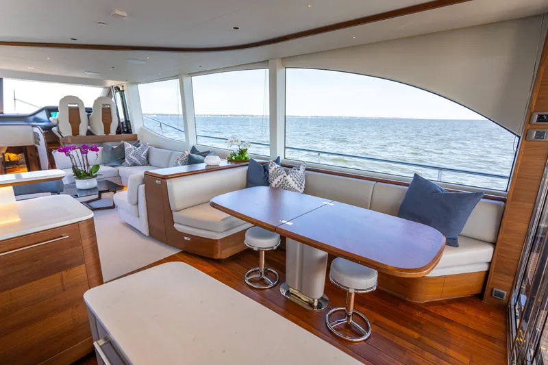 Slide: The Image of Luxurious salon of the Princess Y72 with elegant seating, wooden floors, and large windows overlooking the sea. - 14