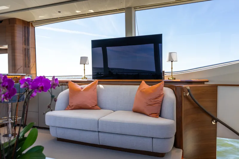 Slide: The Image of The luxurious interior of the 2025 Princess Y72 features a sleek sofa with orange pillows. - 22
