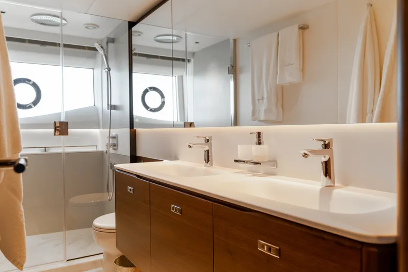 Slide: The Image of Luxurious bathroom with double sinks, glass shower, and sleek wooden cabinets on a yacht. - 42