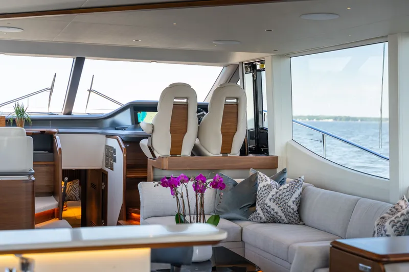 Slide: The Image of The interior of a luxury yacht with white seats, a sofa, and large windows overlooking the sea. - 26