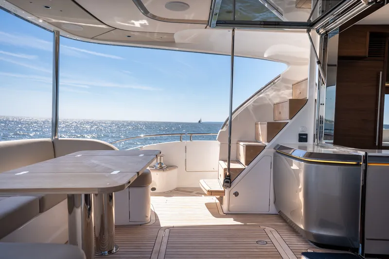 Slide: The Image of The 2025 Princess Y72 yacht features a sleek deck with seating area and stairs, surrounded by ocean views. - 8