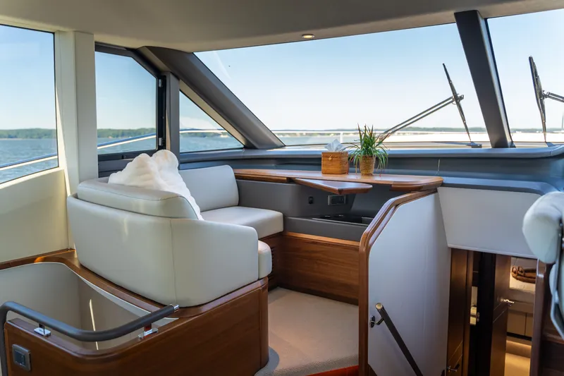 Slide: The Image of Luxurious yacht interior with white leather seating and large windows offering a sea view. - 24