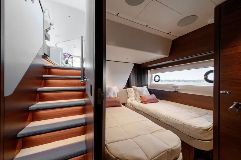 Slide: The Image of The 2025 Princess Y72 cabin features two single beds, wood paneling, and a porthole. - 44
