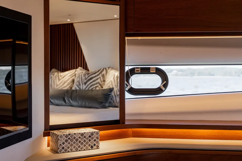 Slide: The Image of Luxurious yacht interior with elegant wood accents and a window overlooking the sea. - 49