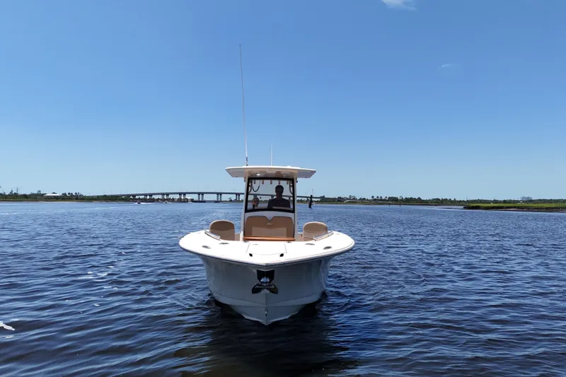 Slide: The Image of 2021 Scout 277 LXF boat cruising on a sunny day with clear blue skies. - 21