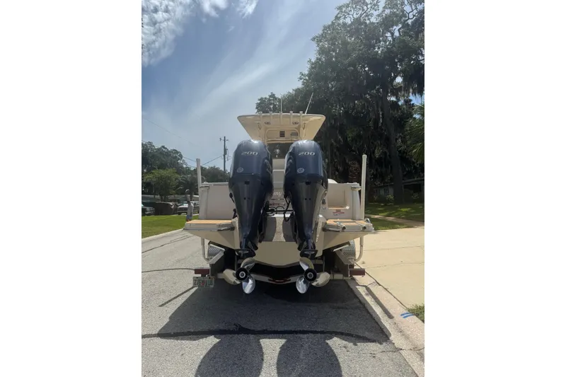 Slide: The Image of 2021 Scout 277 LXF boat with dual outboard motors on a sunny street. - 41