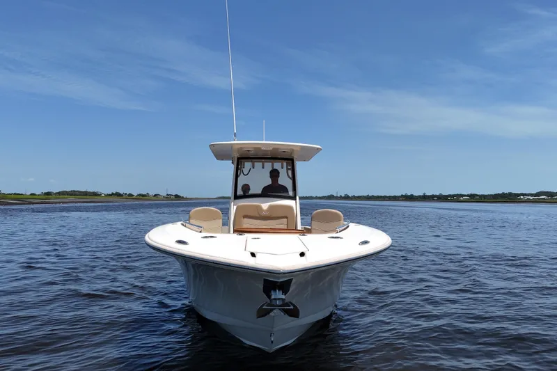 Slide: The Image of 2021 Scout 277 LXF boat on calm water under clear blue sky. - 27