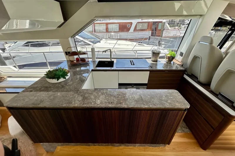 Slide: The Image of Luxurious yacht kitchen interior with modern design, featuring sleek countertops and scenic marina views. - 23