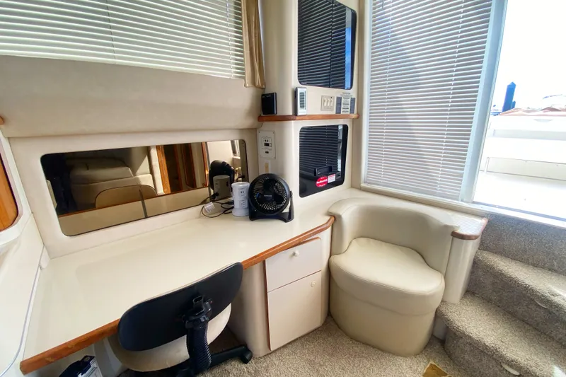 Slide: The Image of 1996 Sea Ray 440 Express Bridge interior with desk, chair, and window blinds. - 13