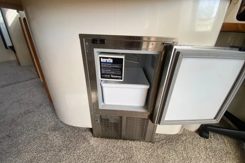 Slide: The Image of Ice maker on 1996 Sea Ray 440 Express Bridge yacht, open door, carpeted interior. - 21