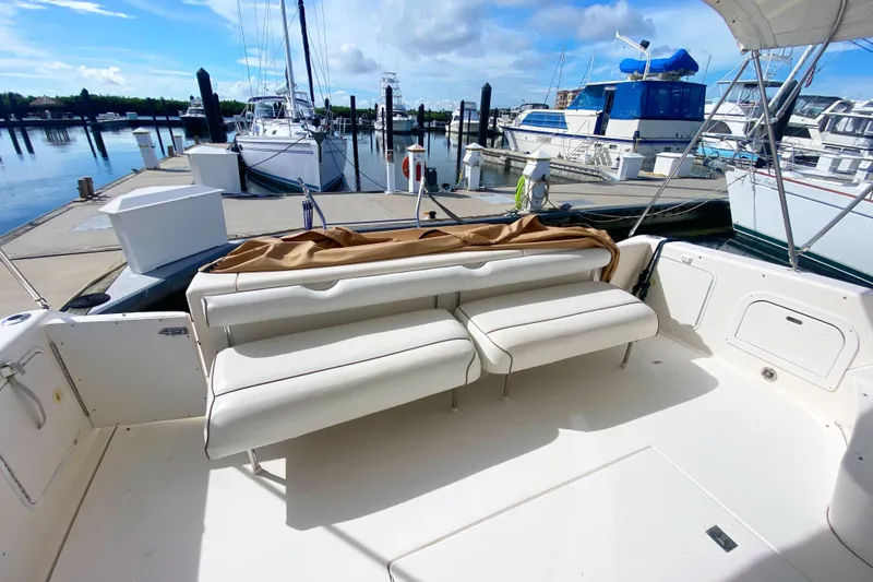 Slide: The Image of 1996 Sea Ray 440 Express Bridge yacht with white seating at a marina dock. - 10