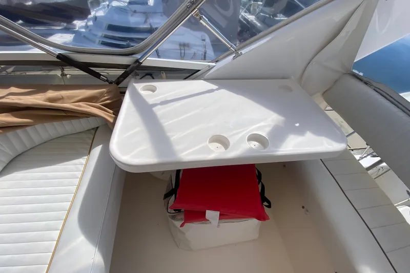Slide: The Image of Interior of 1996 Sea Ray 440 Express Bridge with seating and table setup. - 42