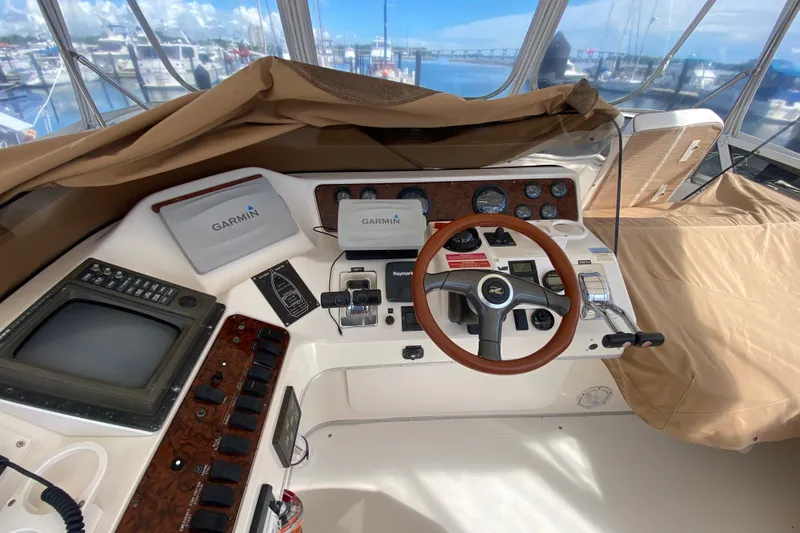 Slide: The Image of Cockpit of 1996 Sea Ray 440 Express Bridge with Garmin navigation systems and wooden steering wheel. - 38