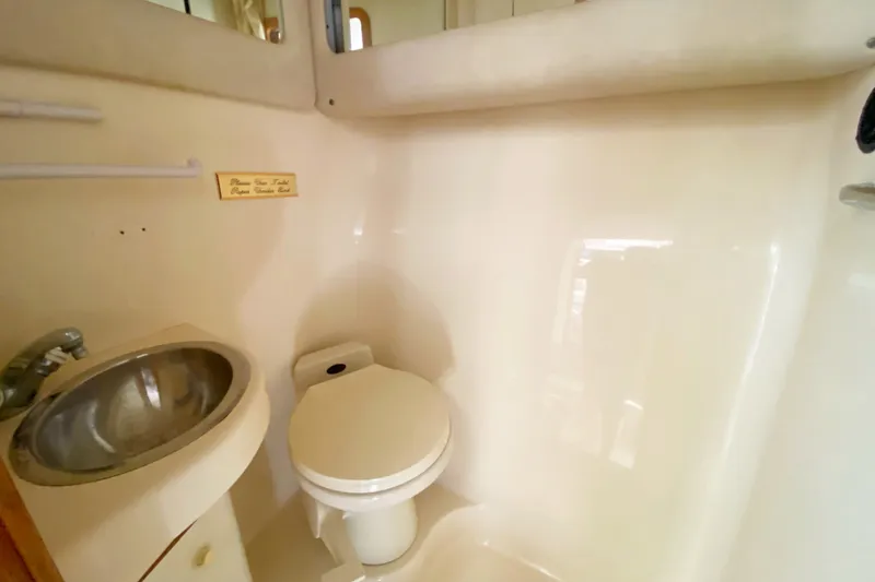 Slide: The Image of 1996 Sea Ray 440 Express Bridge bathroom with sink and toilet. - 33