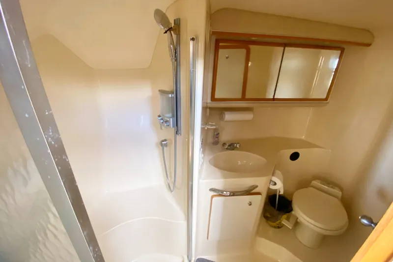 Slide: The Image of Bathroom interior of 1996 Sea Ray 440 Express Bridge yacht, featuring shower, sink, and toilet. - 29