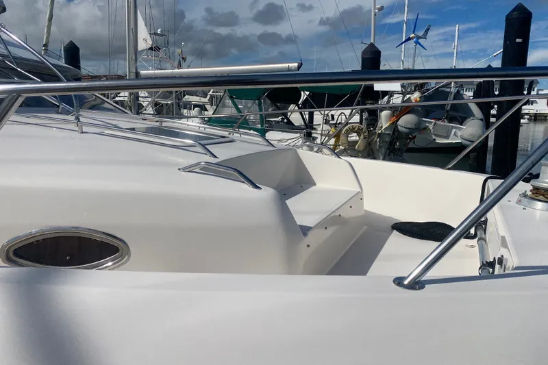 Slide: The Image of 1996 Sea Ray 440 Express Bridge yacht docked, featuring sleek white deck and stainless steel railings. - 9