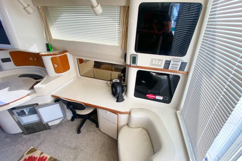 Slide: The Image of Interior of 1996 Sea Ray 440 Express Bridge with desk, chair, and modern amenities. - 14