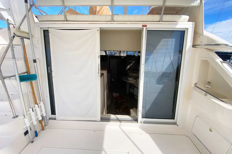 Slide: The Image of 1996 Sea Ray 440 Express Bridge yacht interior entrance with sliding doors and deck equipment. - 11