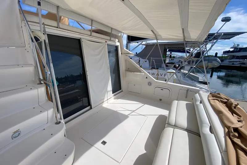 Slide: The Image of 1996 Sea Ray 440 Express Bridge yacht interior with seating and canopy, docked at marina. - 35
