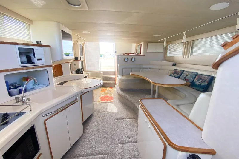 Slide: The Image of Interior of a 1996 Sea Ray 440 Express Bridge yacht, featuring a modern kitchen and seating area. - 18
